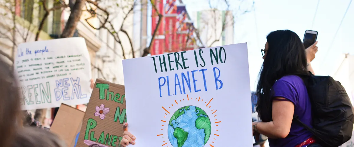 UK SRS consultation next steps — climate demonstrators with a There Is No Planet B placard