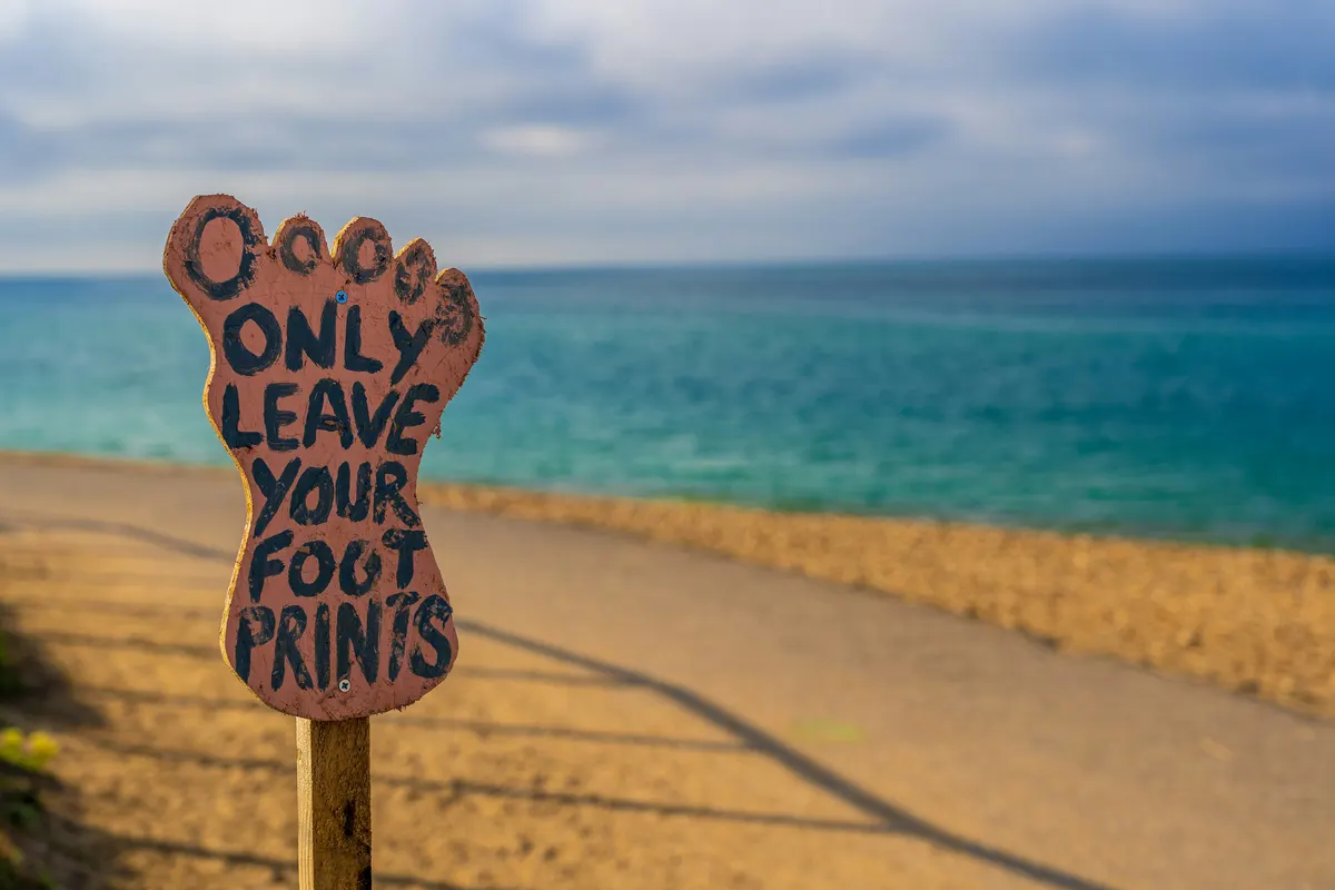 UK SRS S2 and SECR energy and carbon reporting — a footprints sign on a coastal path